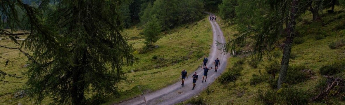Bovenaanzicht van collega's die de Alpentocht lopen op een bergpad.