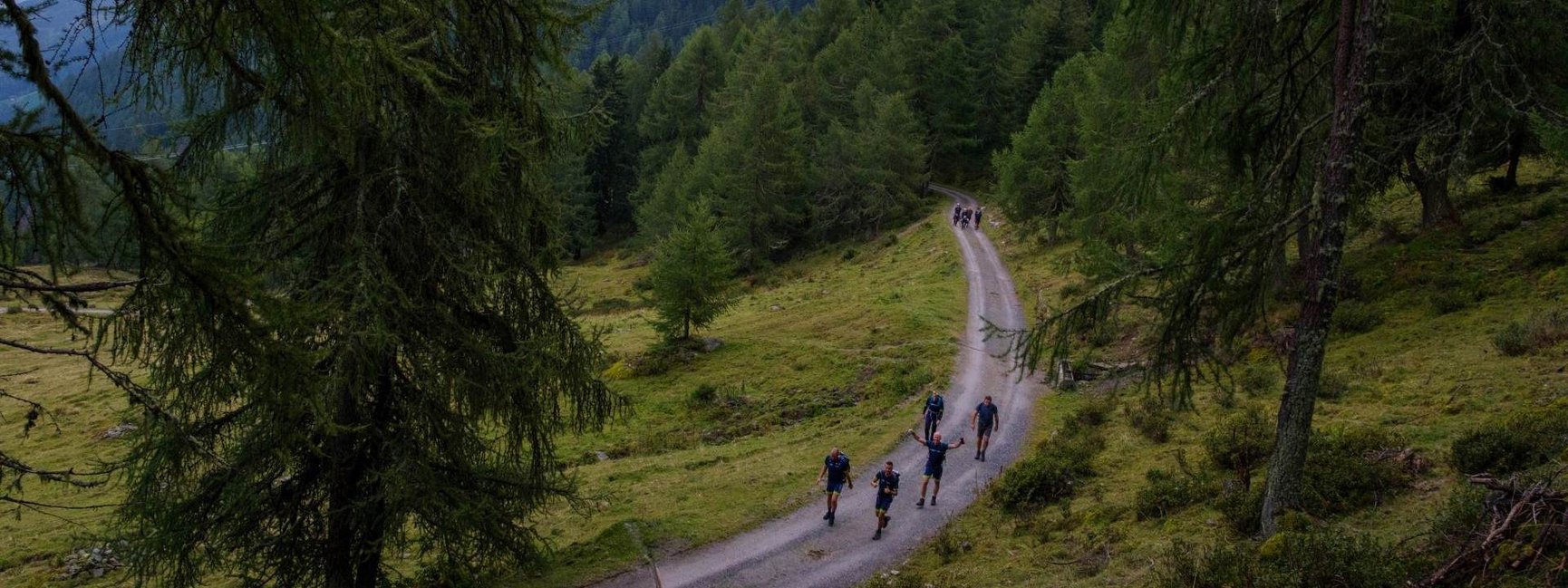 Bovenaanzicht van collega's die de Alpentocht lopen op een bergpad.